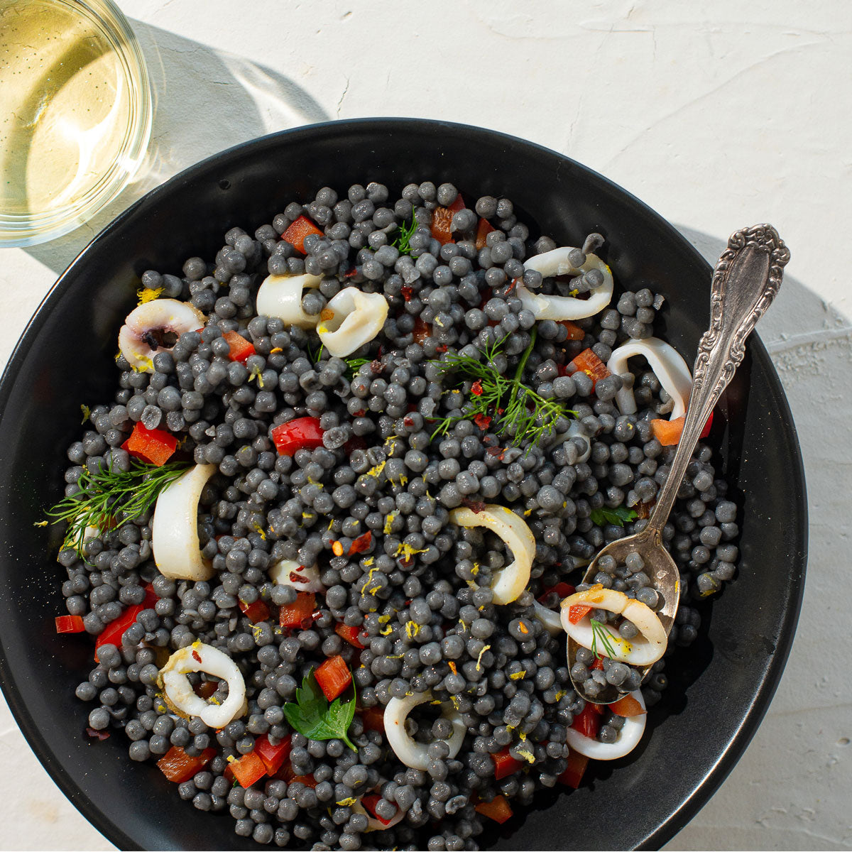 Squid ink couscous dish with calamari and Greek olive oil